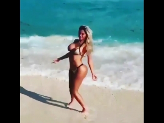 young tanned beauty with a huge curvy ass walks on the beach, non-porn